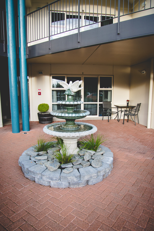An outside area with a water fountain and two chairs